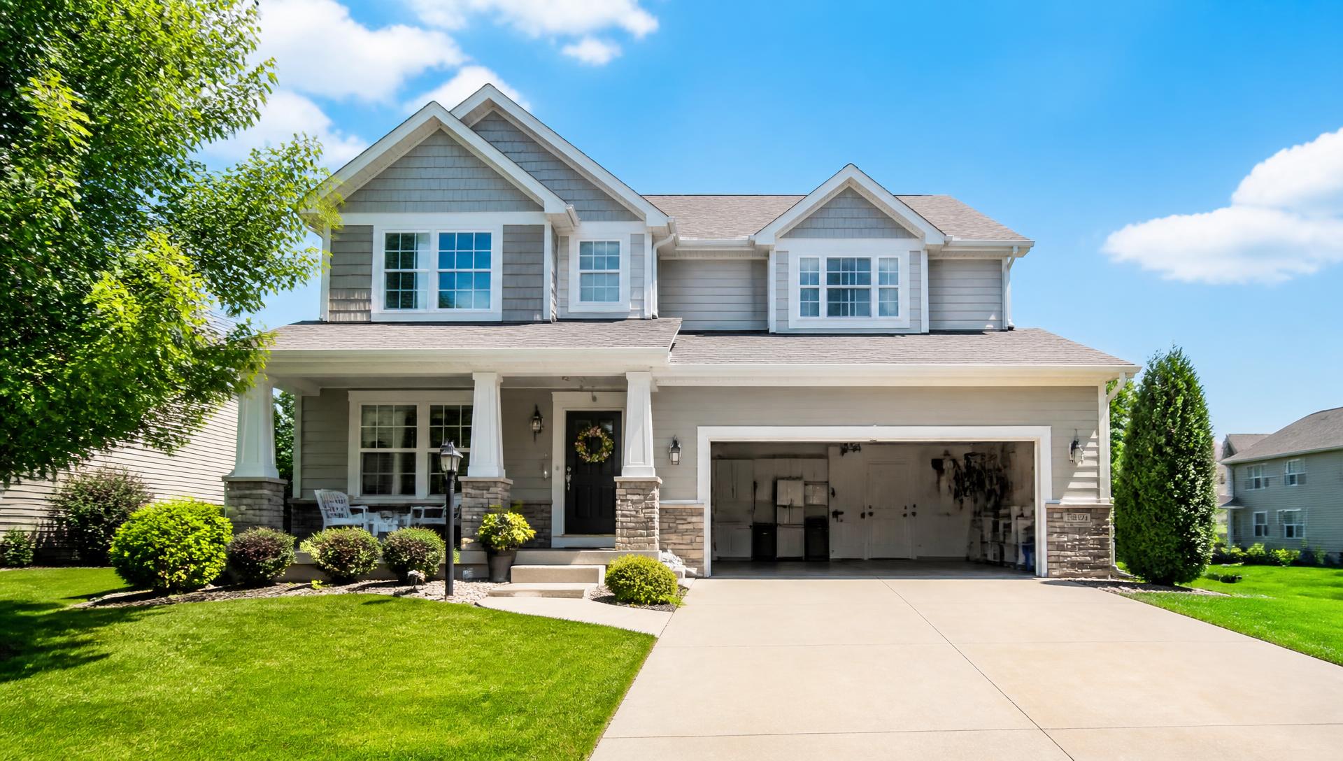 Suburban home with an open garage ready for a junk removal cleanout